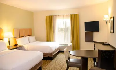 a hotel room with two beds and a table at Candlewood Suites York by IHG in York