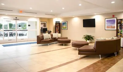 a waiting room with couches and chairs and a tv at Candlewood Suites York by IHG in York