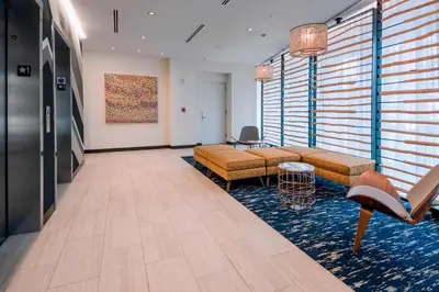 a lobby with couches and chairs in a room with windows at Residence Inn by Marriott Jersey City in Jersey City