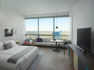 a bedroom with a bed and a couch and a television at AKA University City in Philadelphia