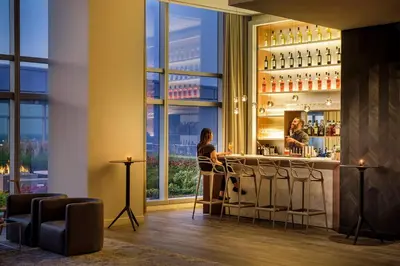 a bar in a hotel with two people standing at a counter at AKA University City in Philadelphia