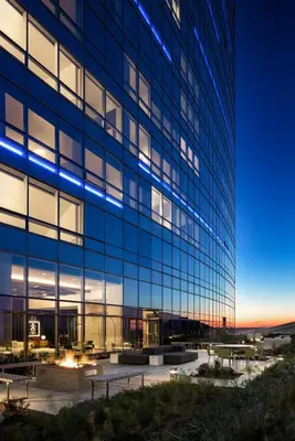 a tall glass building with blue lights on it at AKA University City in Philadelphia