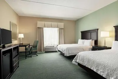 a hotel room with two beds and a desk and a television at Hampton Inn & Suites Mount Joy/Lancaster West, Pa in Manheim