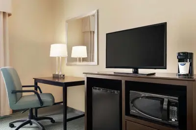 a room with a television and a chair and a desk at Hampton Inn & Suites Mount Joy/Lancaster West, Pa in Manheim