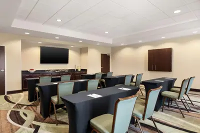 a conference room with tables and chairs and a screen at Hampton Inn & Suites Mount Joy/Lancaster West, Pa in Manheim