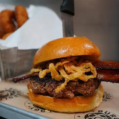 a hamburger with bacon and french fries on a plate at Crowne Plaza HY36 Midtown Manhattan by IHG in New York
