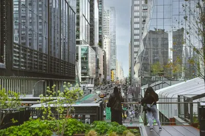 two people walking on a city street with tall buildings at Crowne Plaza HY36 Midtown Manhattan by IHG in New York