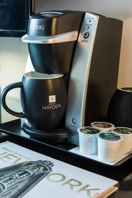 a coffee maker and cups on a black tray at Hotel Hayden New York in New York