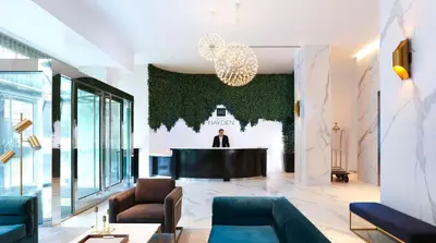 a lobby with a man in a suit standing at a podium at Hotel Hayden New York in New York