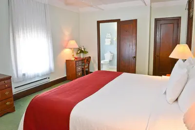a bedroom with a large bed and a bathroom at Penn Wells Hotel in Wellsboro