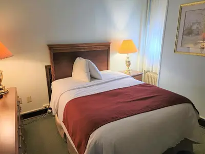 a bedroom with a large bed with two pillows at Penn Wells Hotel in Wellsboro
