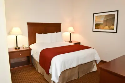 a hotel room with a large bed and two lamps at Penn Wells Lodge in Wellsboro