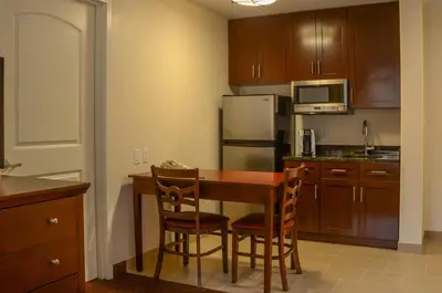 a small kitchen with a wooden table and chairs at Penn Wells Lodge in Wellsboro