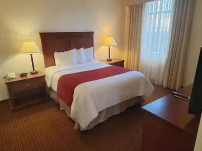 a hotel room with a large bed and a window at Penn Wells Lodge in Wellsboro