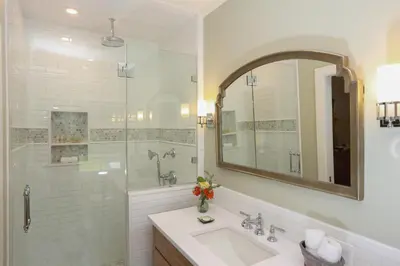 a bathroom with a sink and a shower with a mirror at Woolverton Inn in Stockton