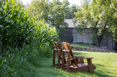 two chairs sitting on a bench in the grass at Woolverton Inn in Stockton