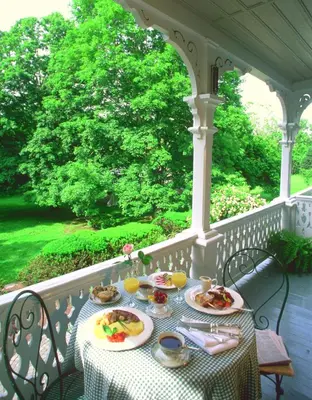a table with plates of food on a porch at Woolverton Inn in Stockton