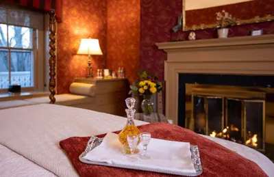 a bed with a tray with two glasses on it at Woolverton Inn in Stockton