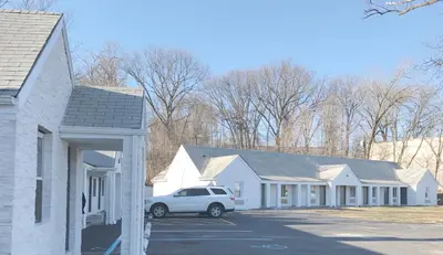a white car parked in a parking lot next to houses at Ramsey Inn & Suites in Ramsey