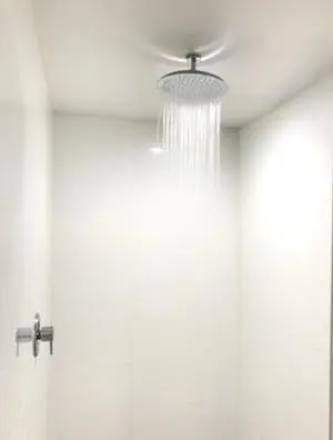a bathroom with a ceiling fan and a chandelier at Ramsey Inn & Suites in Ramsey