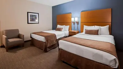 a hotel room with two beds and a chair at Best Western Plus Philadelphia Convention Center Hotel in Philadelphia