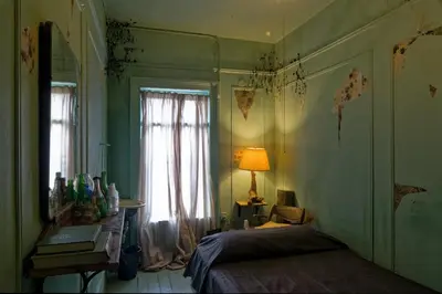 a bedroom with a bed and a window and a lamp at Carlton Arms Hotel in New York