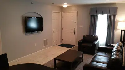 a living room with a couch and a tv on the wall at The Village at Pocono in Blakeslee