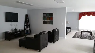 a living room with black chairs and a flat screen tv at The Village at Pocono in Blakeslee