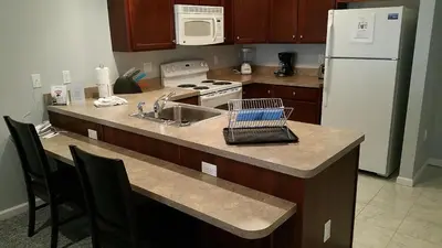 a kitchen with a counter with a sink and a refrigerator at The Village at Pocono in Blakeslee