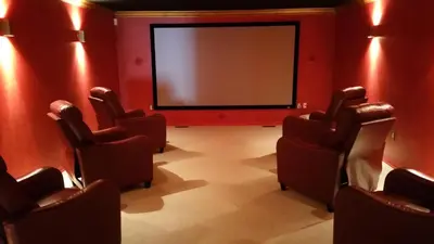 a cinema room with chairs and a projection screen at The Village at Pocono in Blakeslee