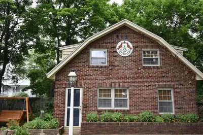 a red brick house with a sign on it at Apple Bin Inn in Willow Street