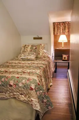 a bedroom with a bed and a lamp and a window at Apple Bin Inn in Willow Street