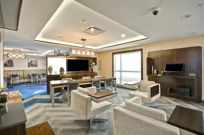 a large living room with a dining area and a living room with chairs and tables at TownePlace Suites by Marriott Cranbury South Brunswick in Cranbury
