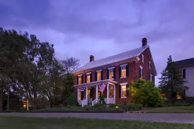 a large brick house with an american flag on it at Pheasant Field Bed and Breakfast in Carlisle