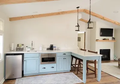 a kitchen with blue cabinets and a table with chairs at Pheasant Field Bed and Breakfast in Carlisle