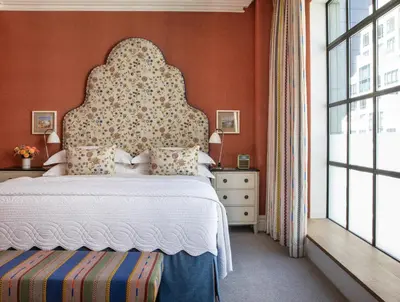 a bedroom with a large bed with an orange wall at The Whitby Hotel in New York