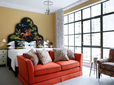 a bedroom with a bed and a red couch at The Whitby Hotel in New York