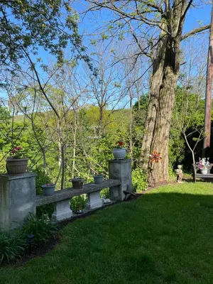a bench in the grass with potted plants on it at Hillcrest Bed and Breakfast in Jim Thorpe