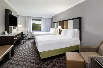 a hotel room with two beds and a desk at Best Western Premier NYC Gateway Hotel in North Bergen