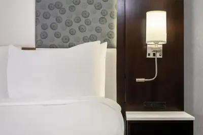 a hotel room with a bed and a light next to it at Best Western Premier NYC Gateway Hotel in North Bergen