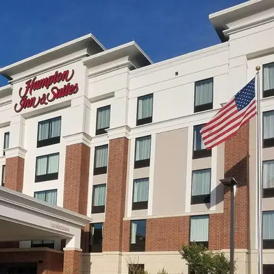 a hotel with an american flag in front of it at Hampton Inn & Suites Newburgh Stewart Airport, NY in Newburgh