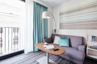 a living room with a purple couch and a table at Park Terrace Hotel in New York