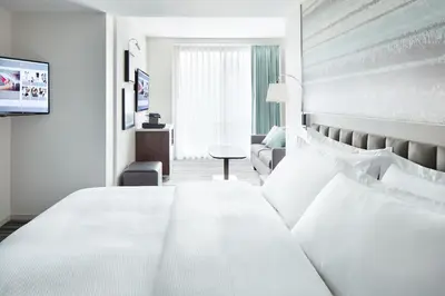 a hotel room with a large white bed and a chair at Park Terrace Hotel in New York
