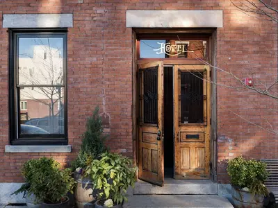 a door to a brick building with a sign on it at Wm. Mulherin's Sons Hotel in Philadelphia