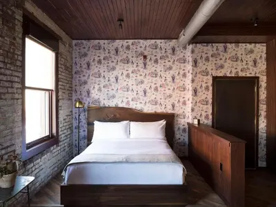 a bedroom with a bed and a brick wall at Wm. Mulherin's Sons Hotel in Philadelphia