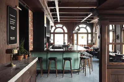 a bar in a restaurant with stools at a counter at Wm. Mulherin's Sons Hotel in Philadelphia