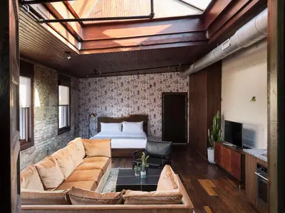 a living room with a couch and a bed at Wm. Mulherin's Sons Hotel in Philadelphia