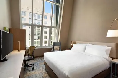 a hotel room with a bed and a large window at Hilton Garden Inn New York Times Square South in New York
