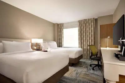 a hotel room with two beds and a desk at Hilton Garden Inn New York Times Square South in New York