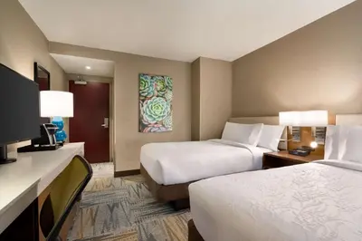 a hotel room with two beds and a flat screen tv at Hilton Garden Inn New York Times Square South in New York